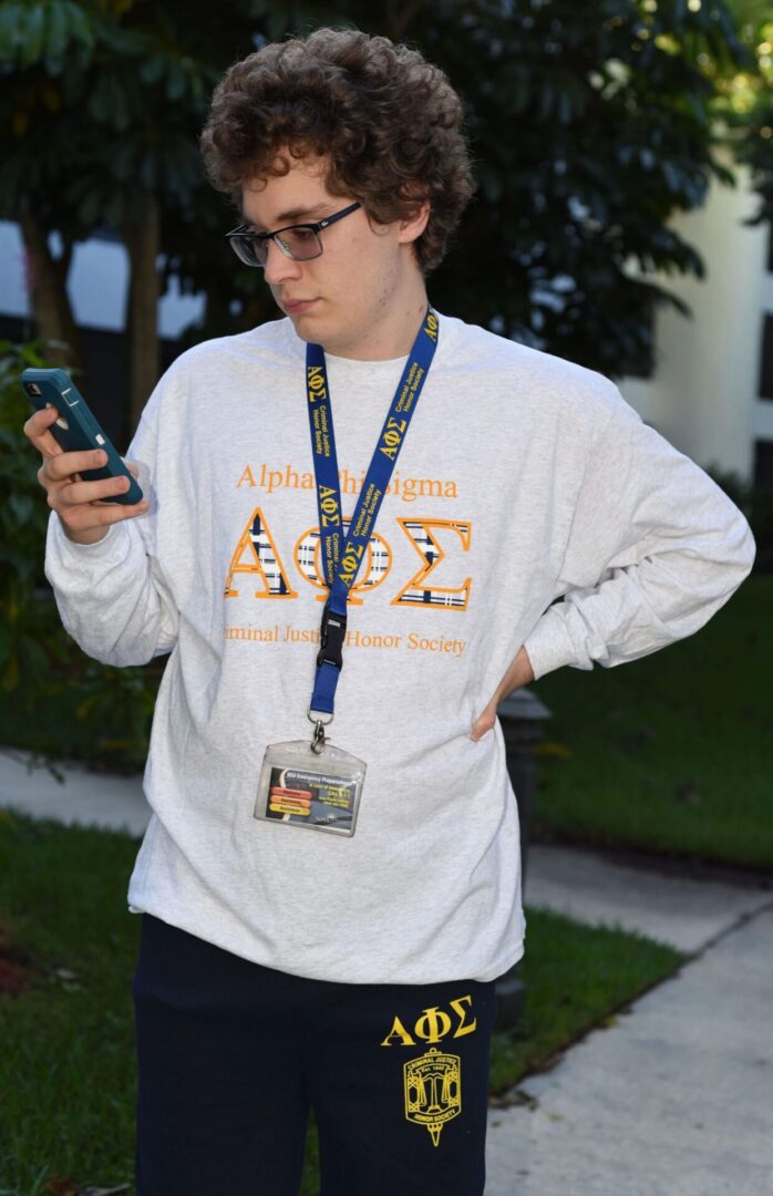 Person checking phone outside in casual attire.