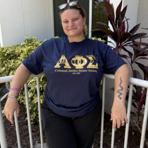 Alpha Phi Sigma member smiling outdoors