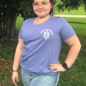Person in blue shirt standing outside.
